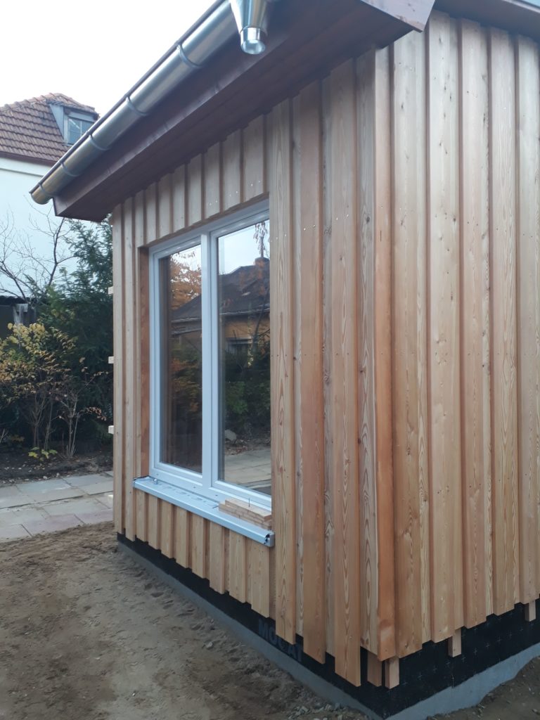 Neubau von Gartenhäusern in Holzrahmenbauweise mit Boden-Deckel-Holzfassade aus sibirischer Lärche