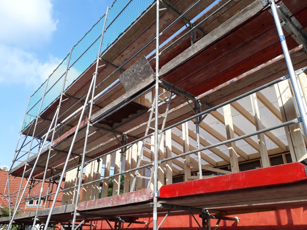 Holzrahmenbau-Aufstockung eines Büro- und Lagergebäudes  mit aufgeständertem Treppenpodest und einer waagerechten Rhombusleisten-Fassade in sibirischer Lärche