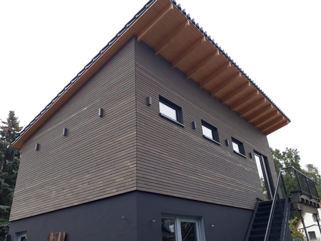 Holzrahmenbau-Aufstockung eines Büro- und Lagergebäudes  mit aufgeständertem Treppenpodest und einer waagerechten Rhombusleisten-Fassade in sibirischer Lärche