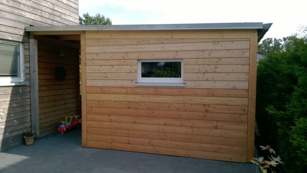 Carport mit Abstellraum in Holzrahmenbau und waagerechter Holzfassade in europäischer Lärche